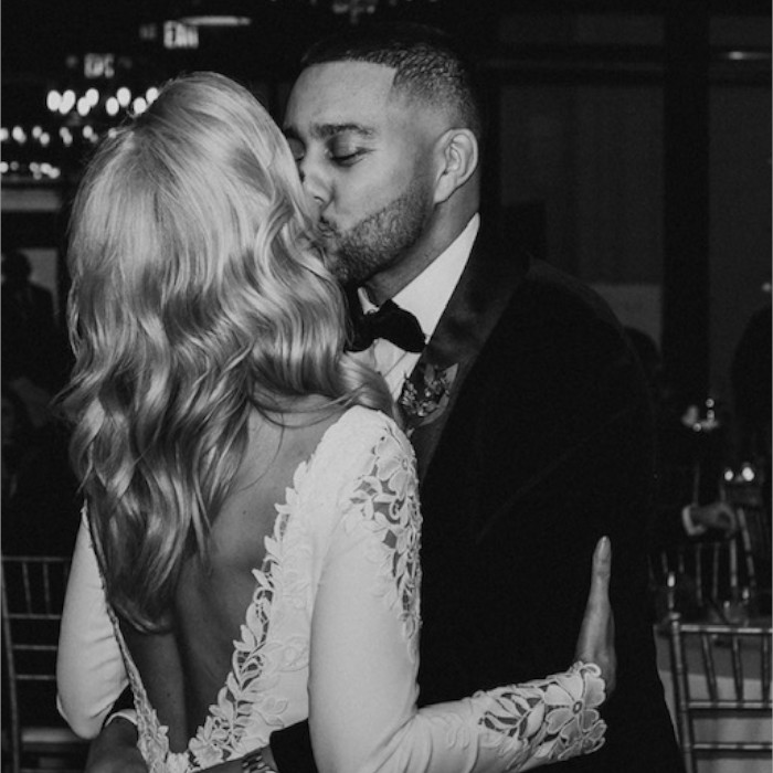 Black and white photo of a wedding couple kissing.