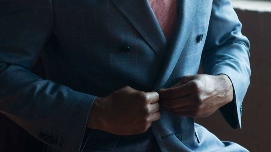 Man buttoning blue jacket