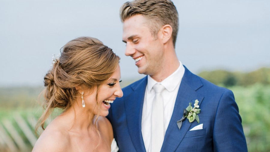 Wedding portrait of a couple smiling towards each other.